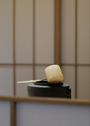 Tea ceremony scoop perched on top of water vessel