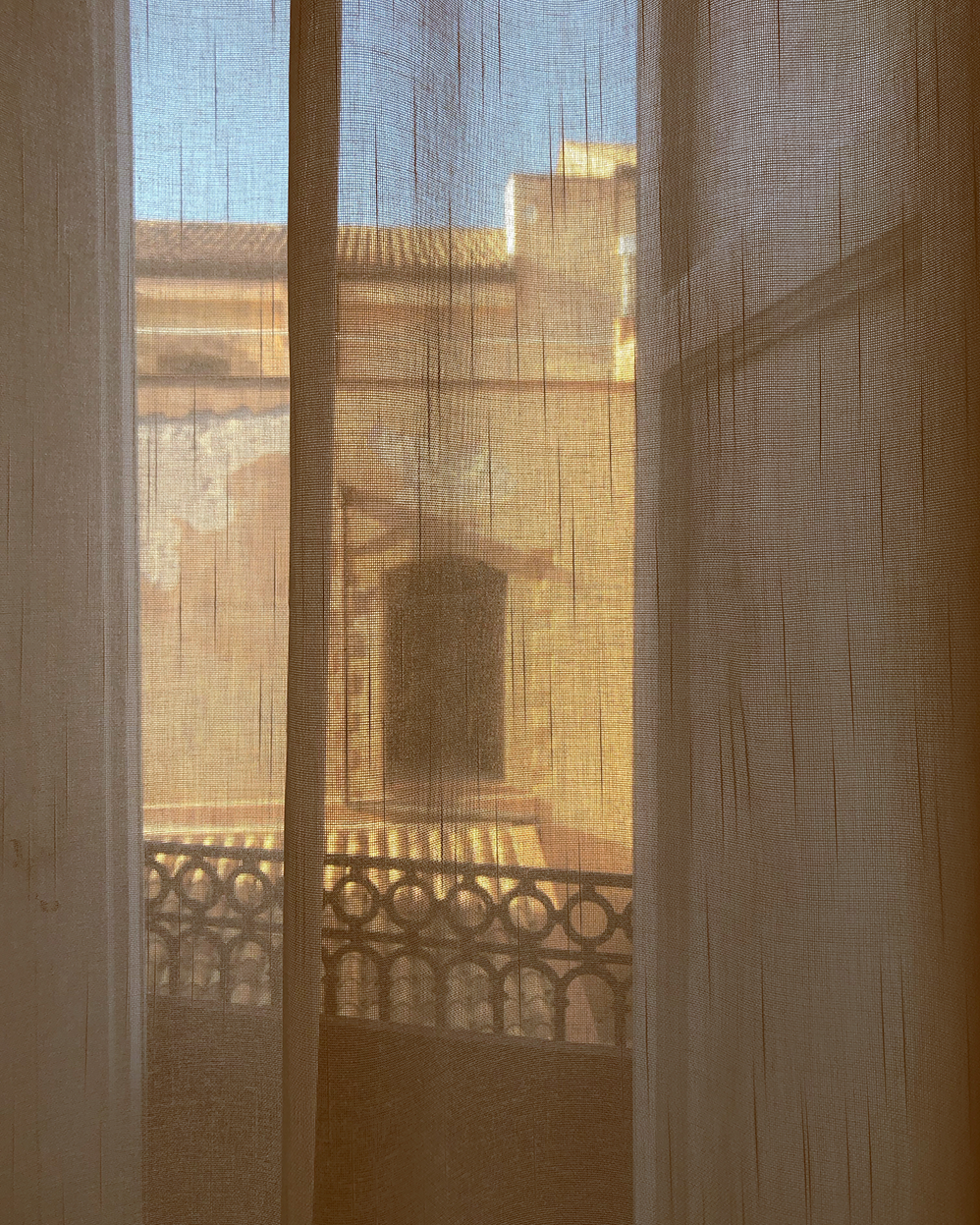 This image shows light gently filtered through a curtain in the noon light in Sicily. 