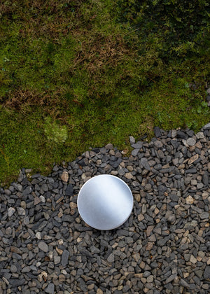 Silver supplement storage vessel in a Japanese garden with gravel and moss