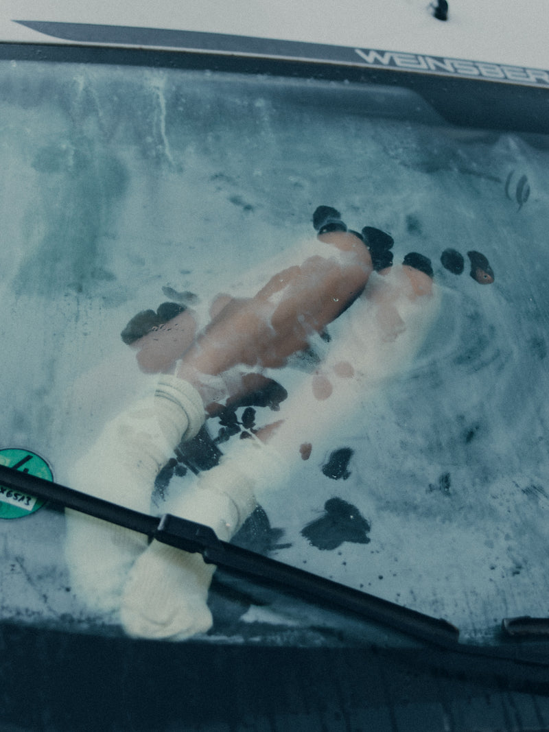 A photo of a person inside a car on a foggy morning