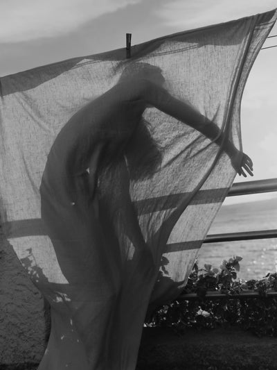 Black and White image of a womans shadow behind a washing line