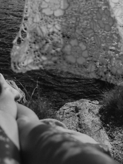 A photo of a woman lying in the early morning sun beside the sea
