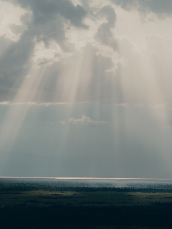 A photo of sun rays through clouds over the sea