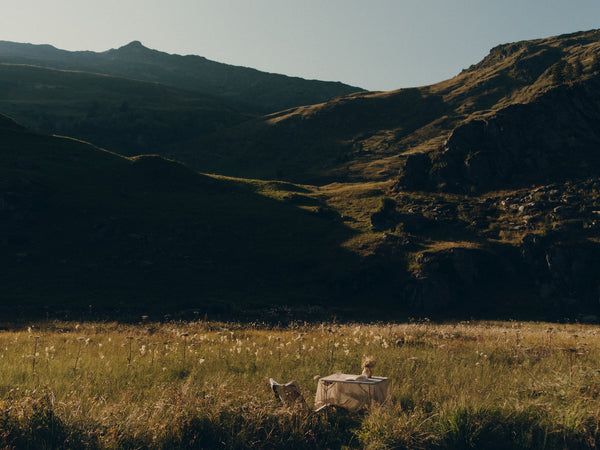 A table stands alone in a field in the sun creating a sanctuary feeling.