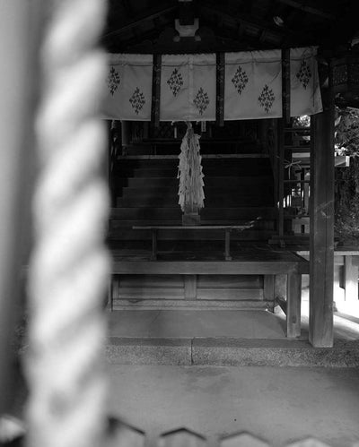 Traditional Japanese Shinto shrine with torii gates in black and white.
