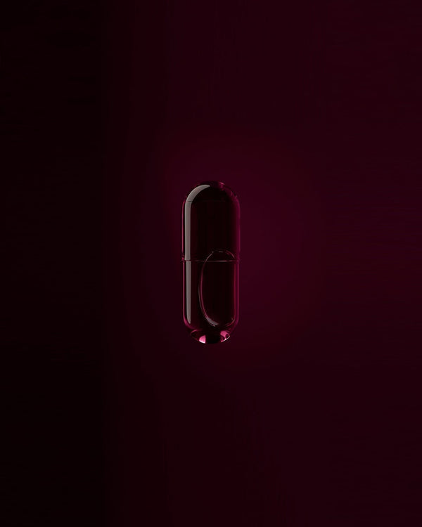 A magenta food supplement capsule NOON ALL DAY with Vitamin D3 and Vitamin K2 in Hand Harvested Macadamia Oil.