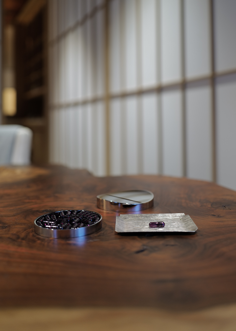 Three metallic objects on a wooden surface with a blurred background