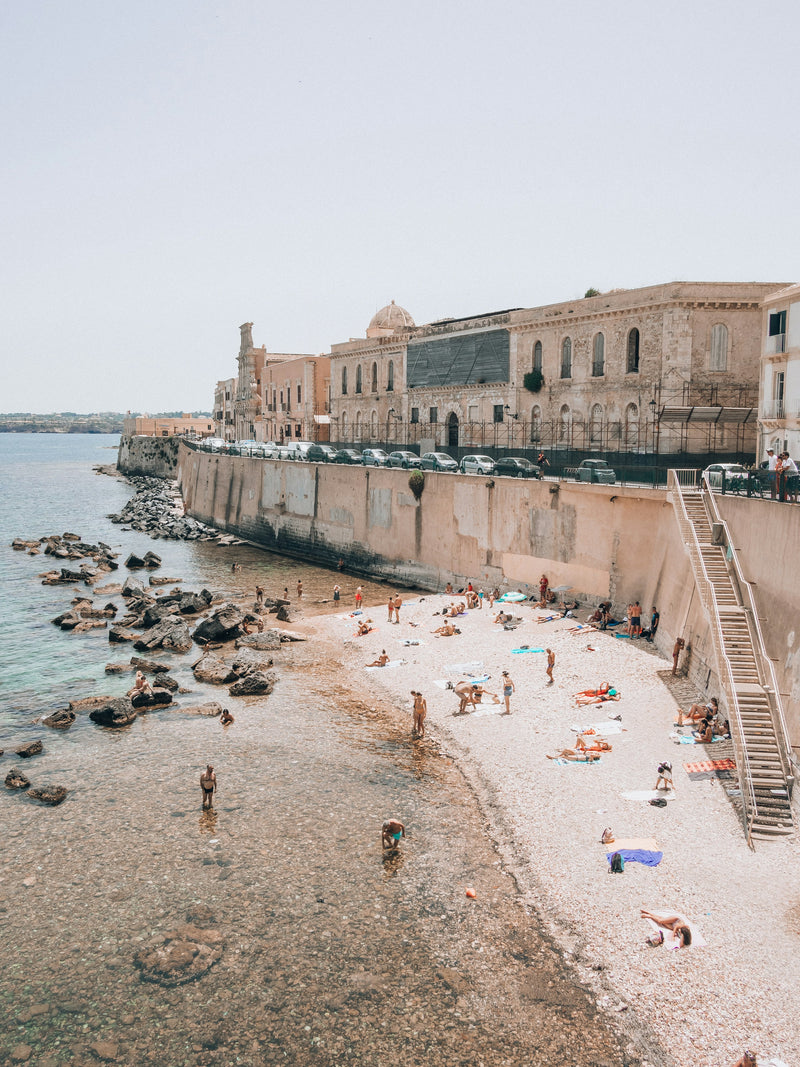 People swimming at the beach in Ortigia in the early morning