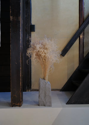 decorative vase with dried plants on a staircase at poj studio in kyoto
